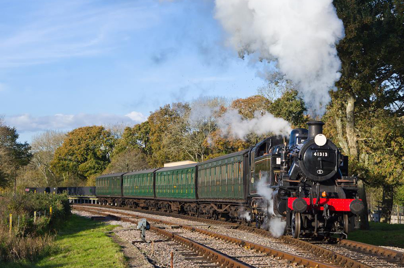 A steam train locomotive on tracks on the Isle of Wight