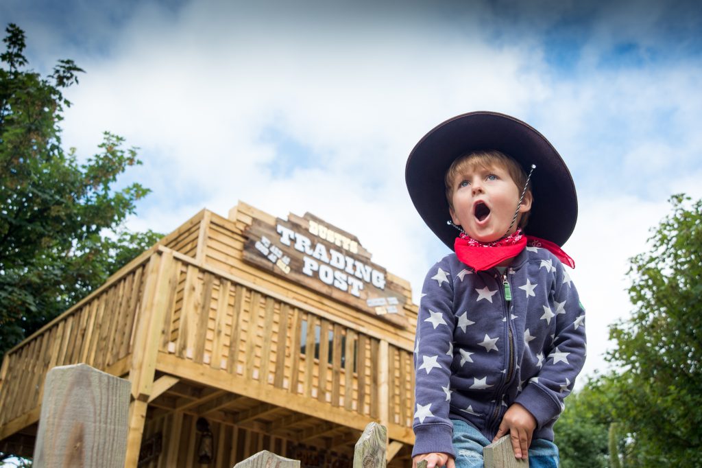 A boy dressed as a cowboy outside a wooden shop at Blackgang Chine, Isle of Wight