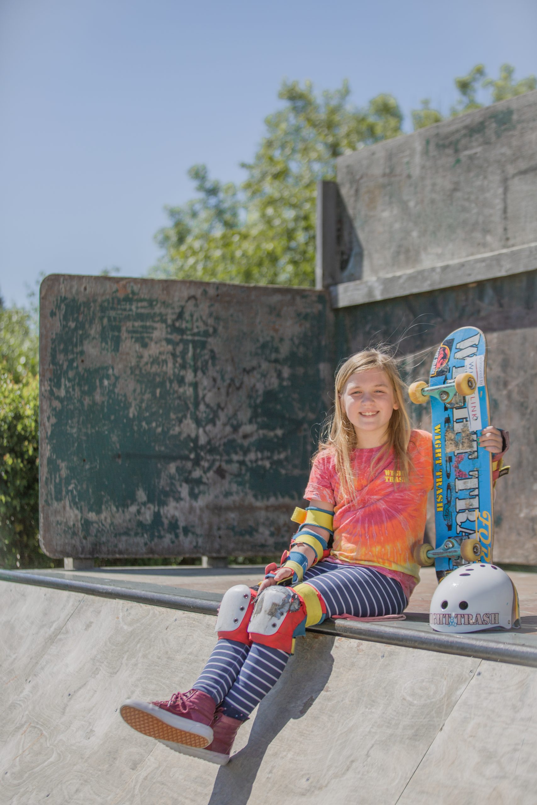 Skateboarder Martha Eggleton with her skateboard and helmet at an Isle of Wight skate park