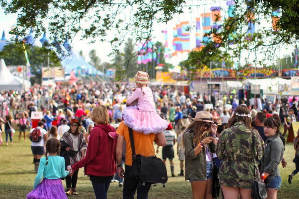 A family walking through the Isle of Wight Festival
