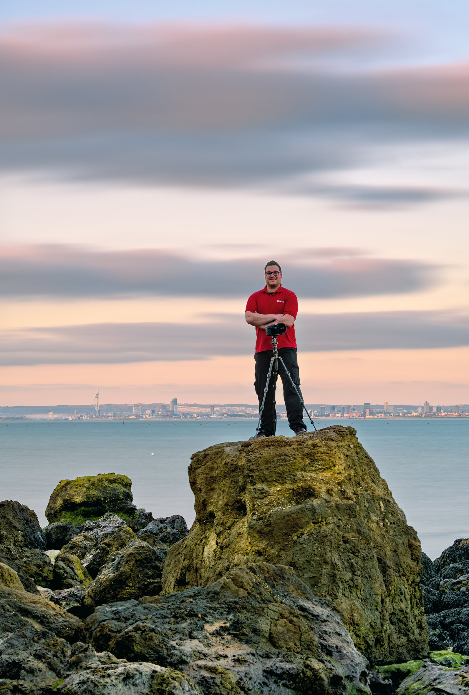 Isle of Wight Photographer Neil Southwell stands on a rock with his camera at Seagrove Bay