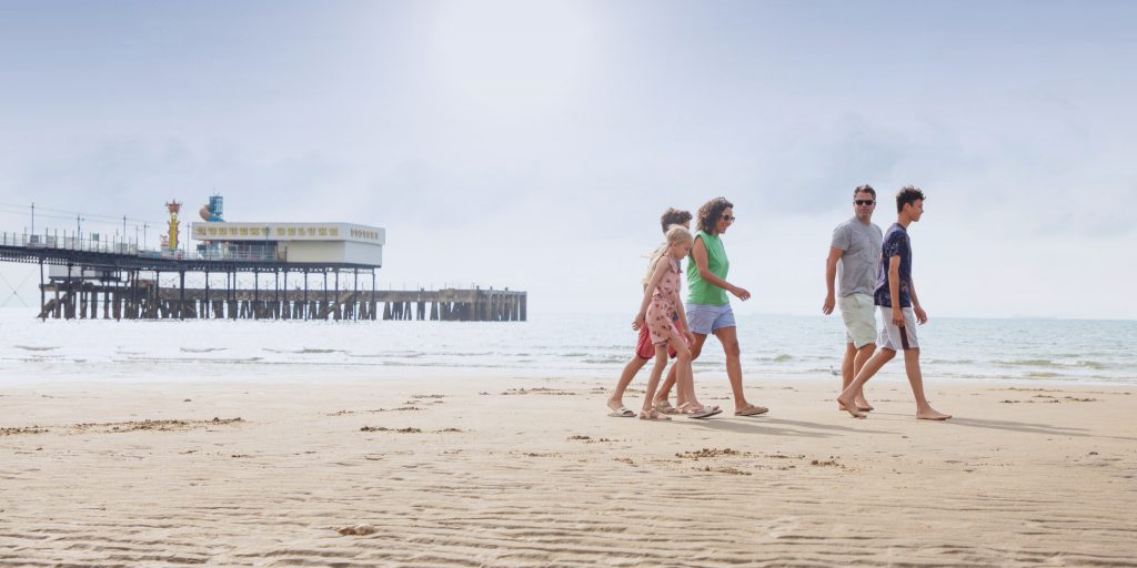 A family walking across Sandown beach on the Isle of Wight