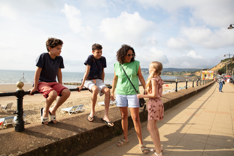 A family of four talking on the promenade of Sandown Beach, Isle of Wight