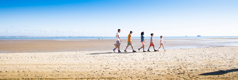 A family walking along a sandy beach, at Appley, Isle of Wight