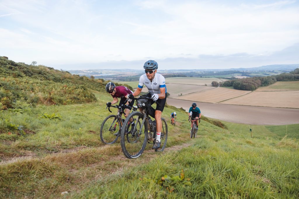 A group of four cyclists going up a hill in the countryside on the Isle of Wight