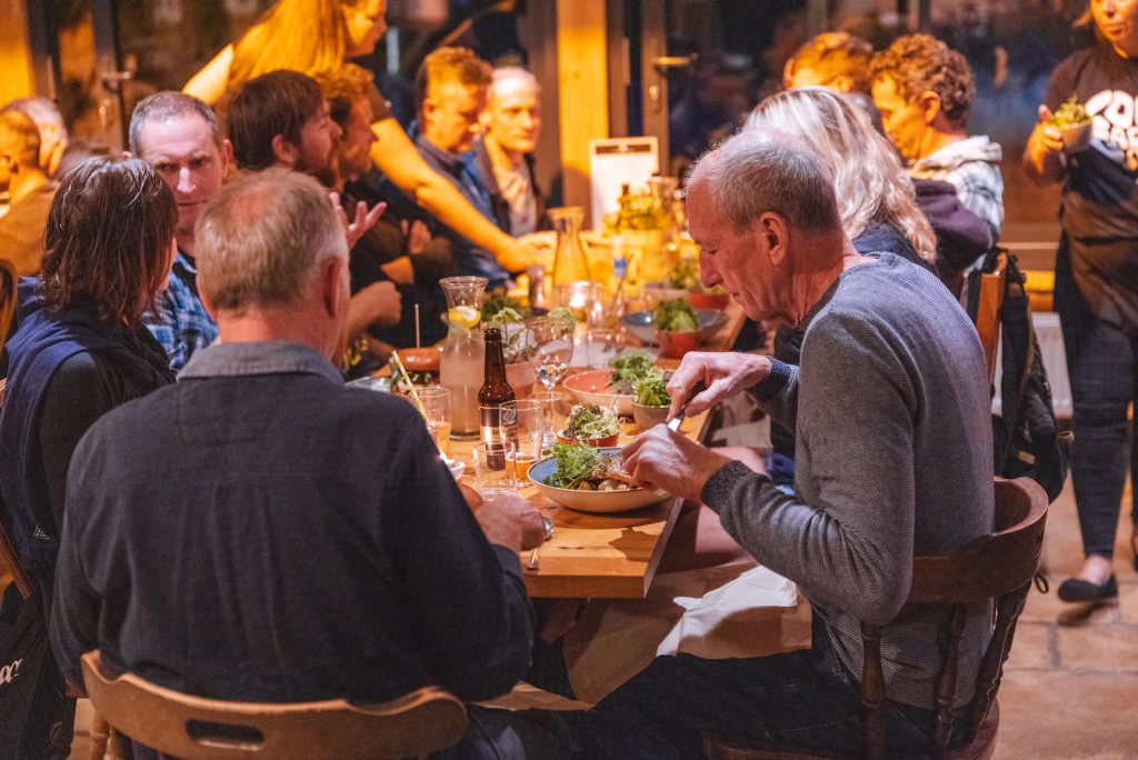 A group of people in the evening at a dinner table at the Garlic Farm on the Isle of Wight