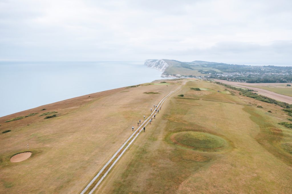 A drone photo of a group of cyclists on a countryside coastal road on the Isle of Wight