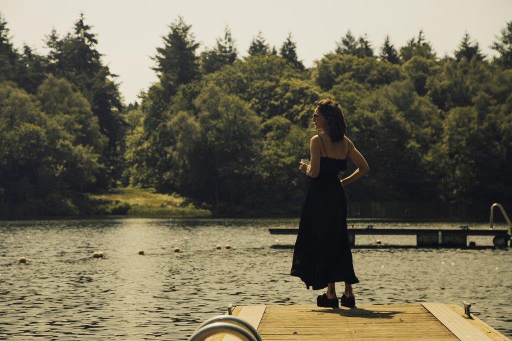 A woman on a pontoon overlooking a lake - Credit Fritton Lake & Edvina Bruzas
