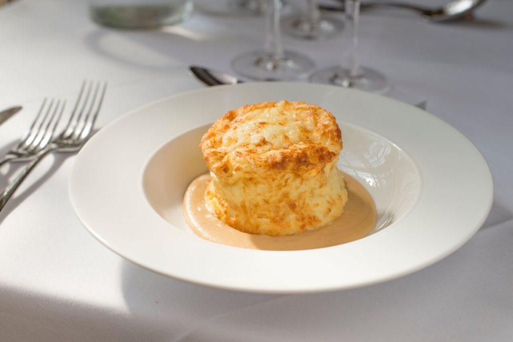 A white plate with a Gallybagger Cheese Souffle at a dining table