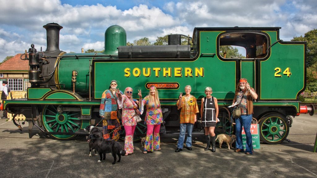 People dressed in 1960s costume in front of a Southern Railway Steam Train, Isle of Wight Steam Railway