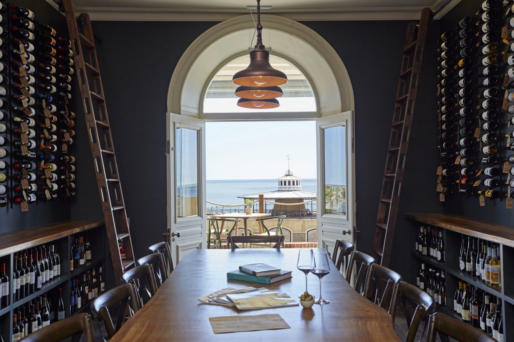 A wine cave of racks, tables and chairs overlooking the sea - Terrace Rooms Isle of Wight