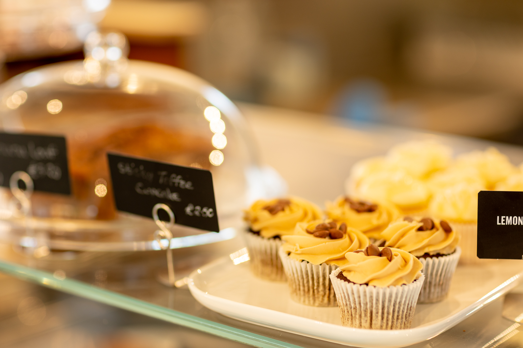 Selection of freshly baked cupcakes and cakes on display in the Harvey Browns café counter.