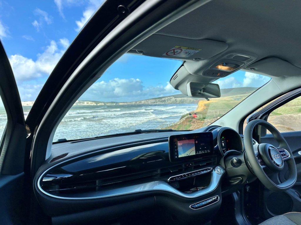 Inside an electric car looking out the windscreen at coastline on the Isle of Wight
