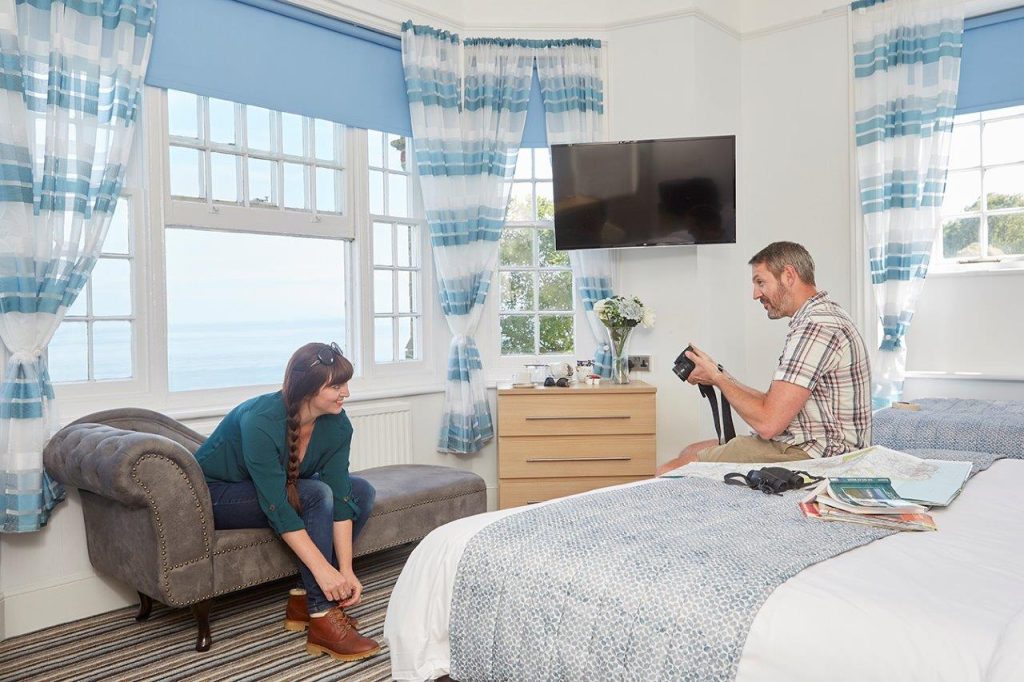 A couple putting on walking boots in a hotel room on the Isle of Wight