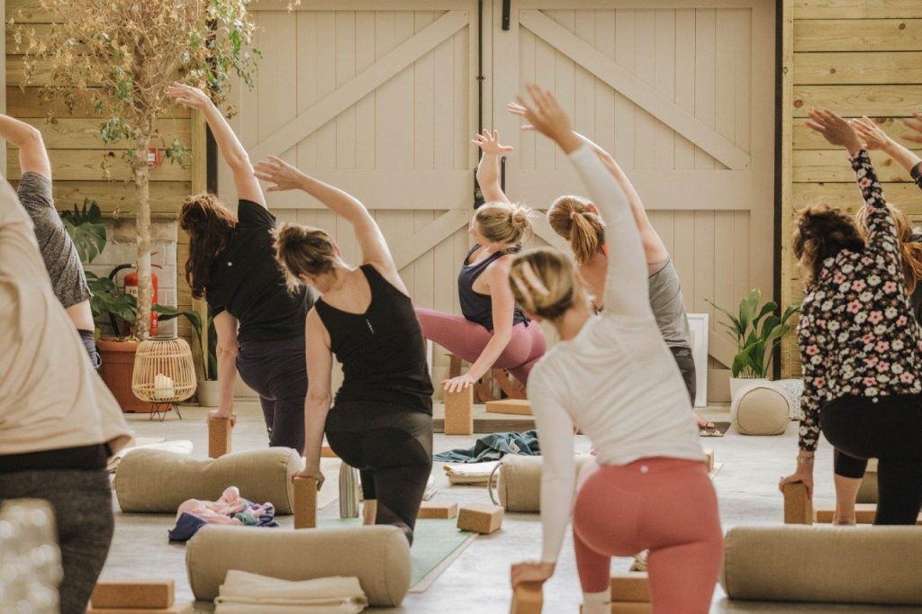 A group of women doing yoga in a barn at Tapnell Farm, Isle of Wight