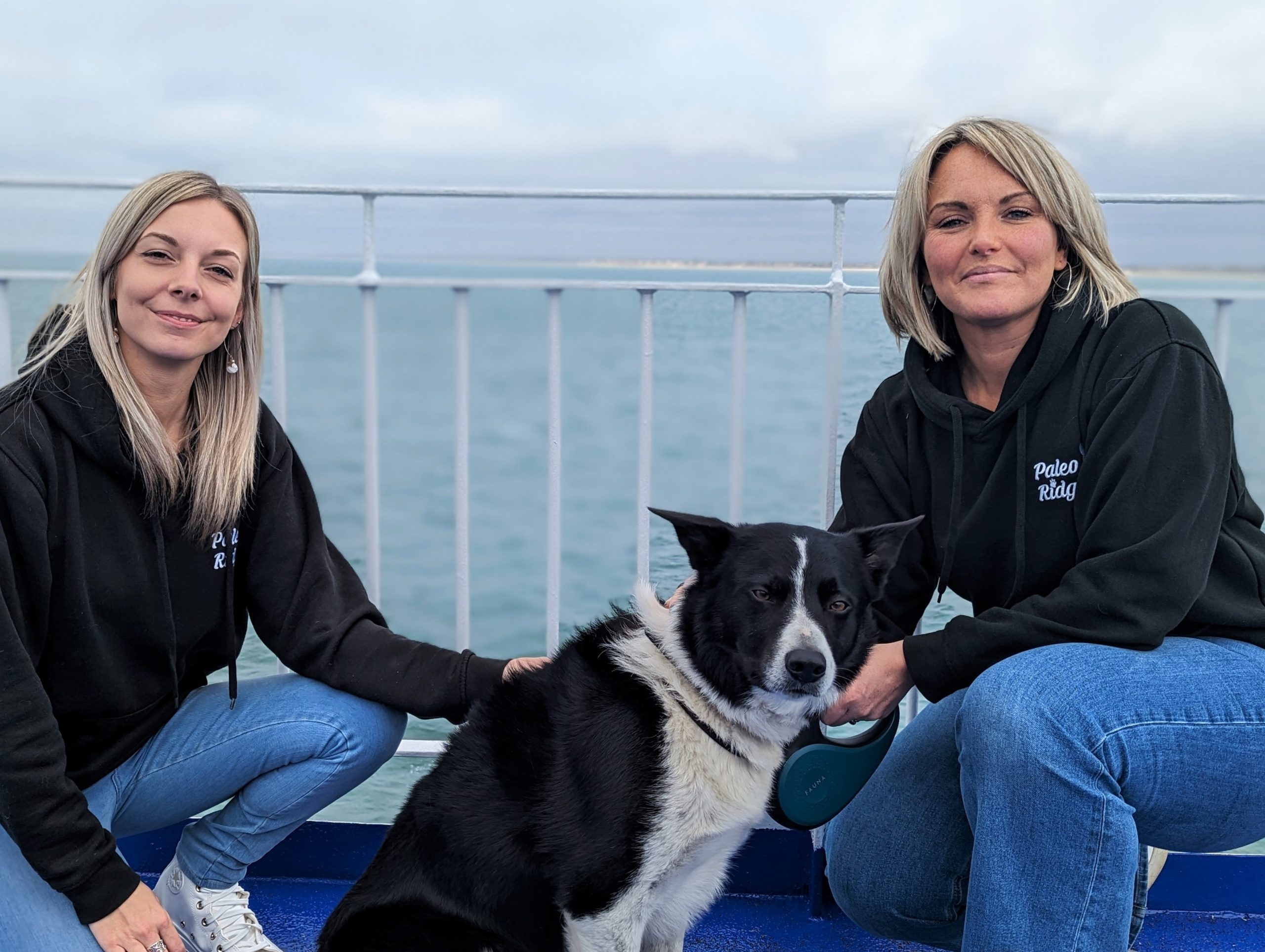 Two women from Paleo Ridge dog food company with a collie dog on a ferry