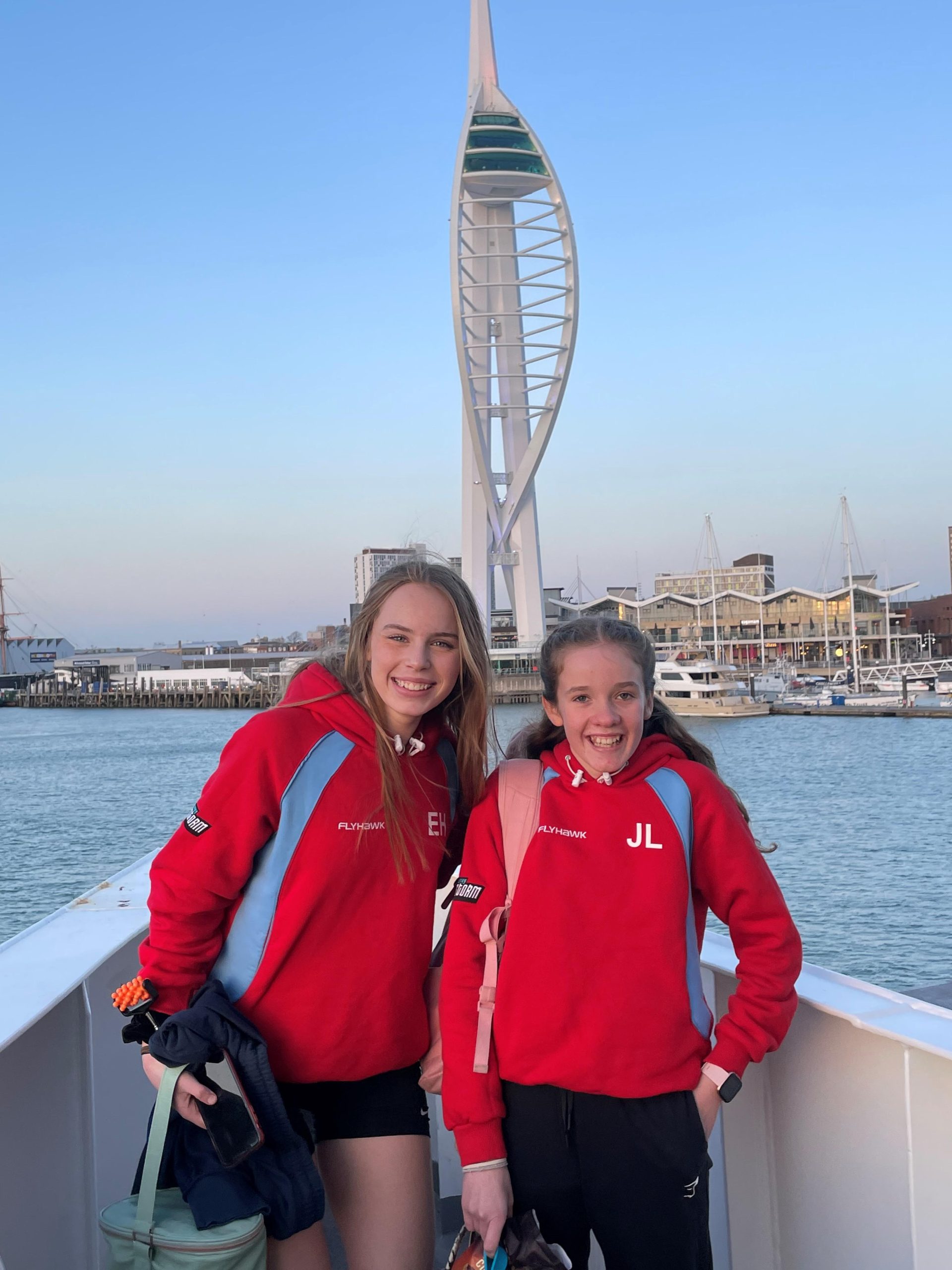 Ella and Jessica netball players on a Wightlink ferry with the Spinnaker Tower in the background