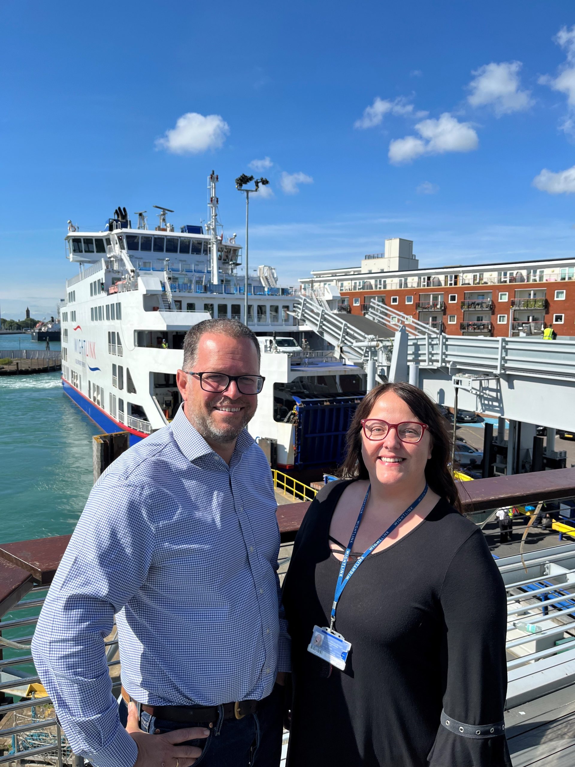 A man and a woman in front of a Wightlink ferry in Portsmouth