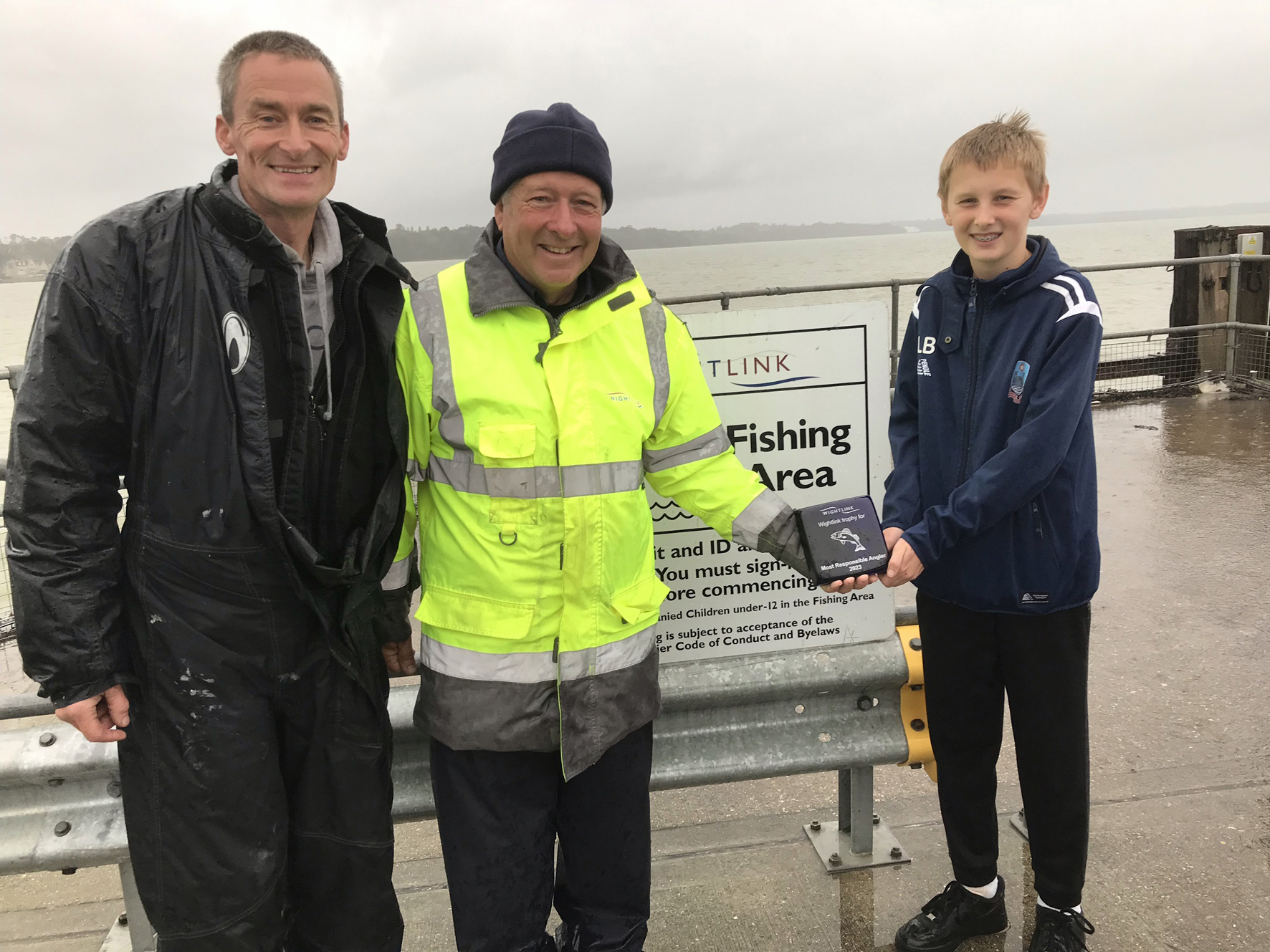 Colin Webb from Vectis Boating and Fishing Club and young angler Louis Bishop with Wightlink Port Operator Marcus Dinnage on Ryde Pier 