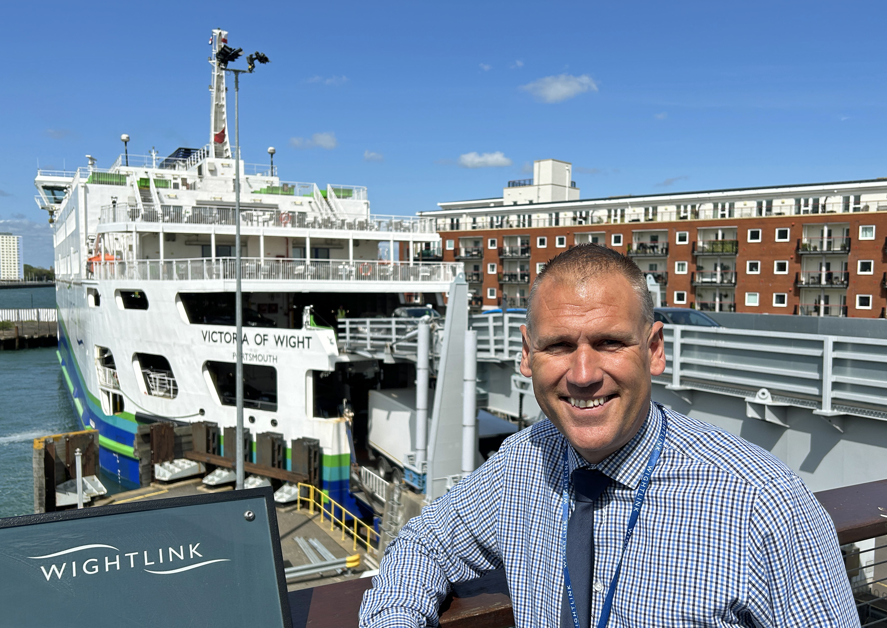 A man wearing a shirt and tie with a ferry in the background