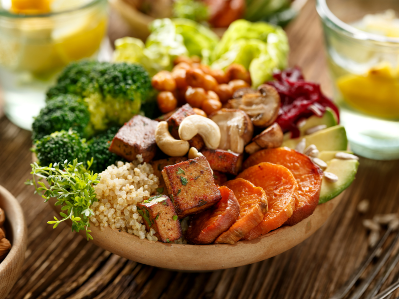 A bowl of delicious looking vegan food on a wooden worktop