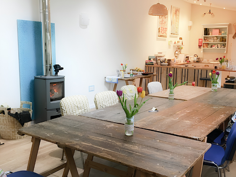 Workshop tables in a cosy barn with log burner and kitchen at Tiny Homes Isle of Wight