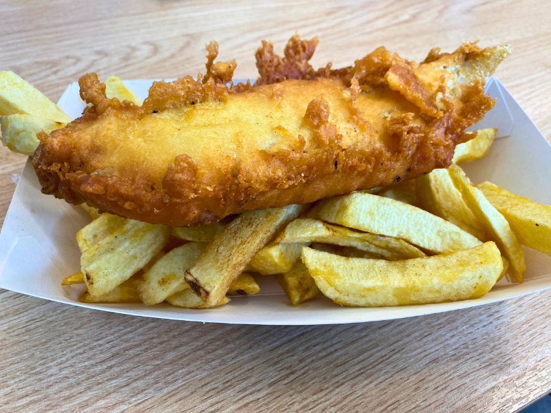 A cardboard carton of chips and battered fish