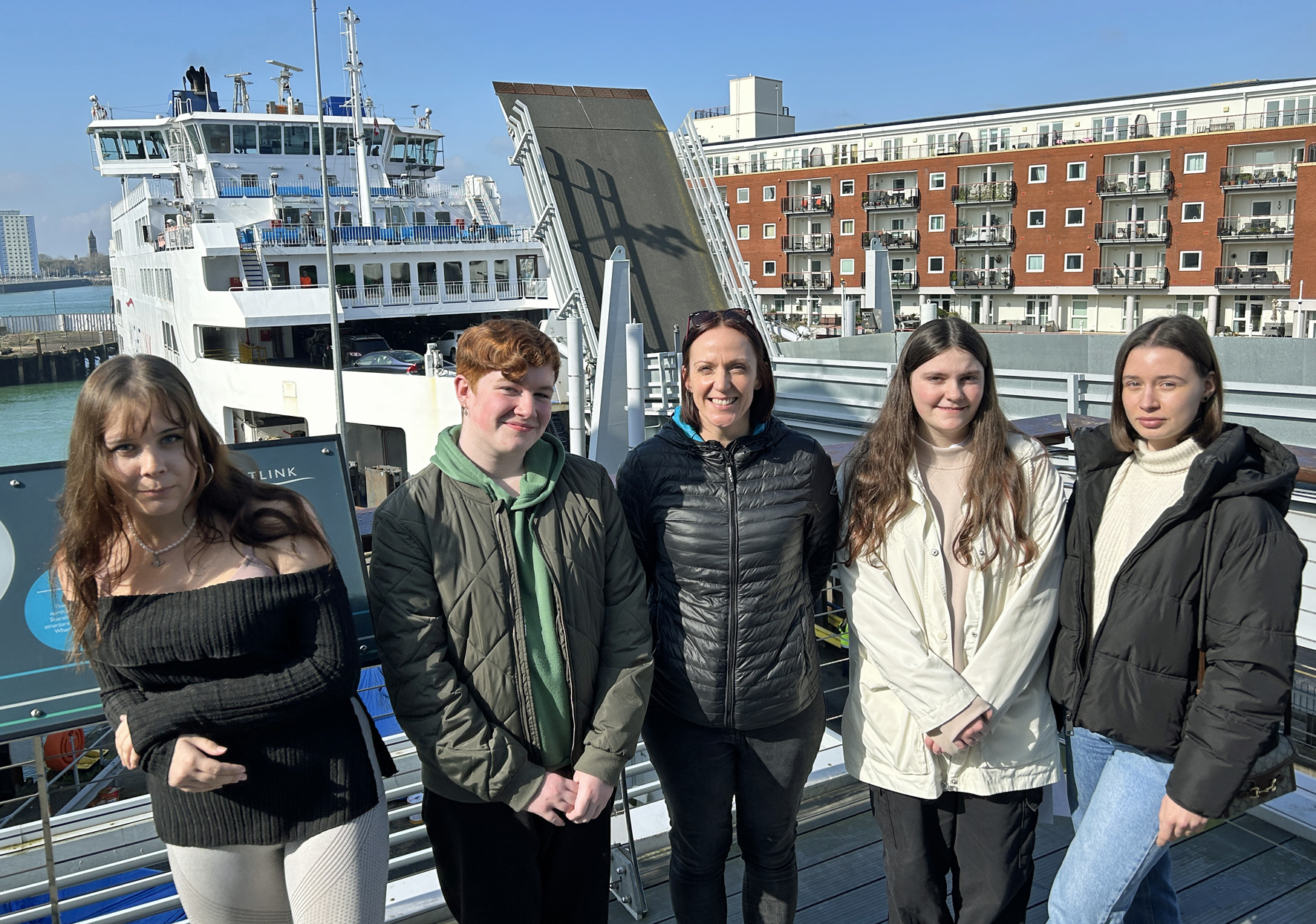 Four Travel and Tourism students and Isle of Wight College tutor Lindsay Davies at Wightlink in front of a ferry and linkspan