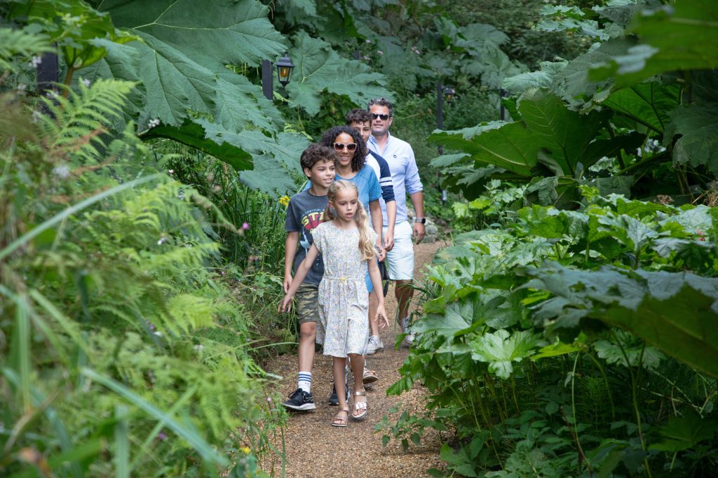 A family of five walk through the plants and trees at Shanklin Chine, Isle of Wight