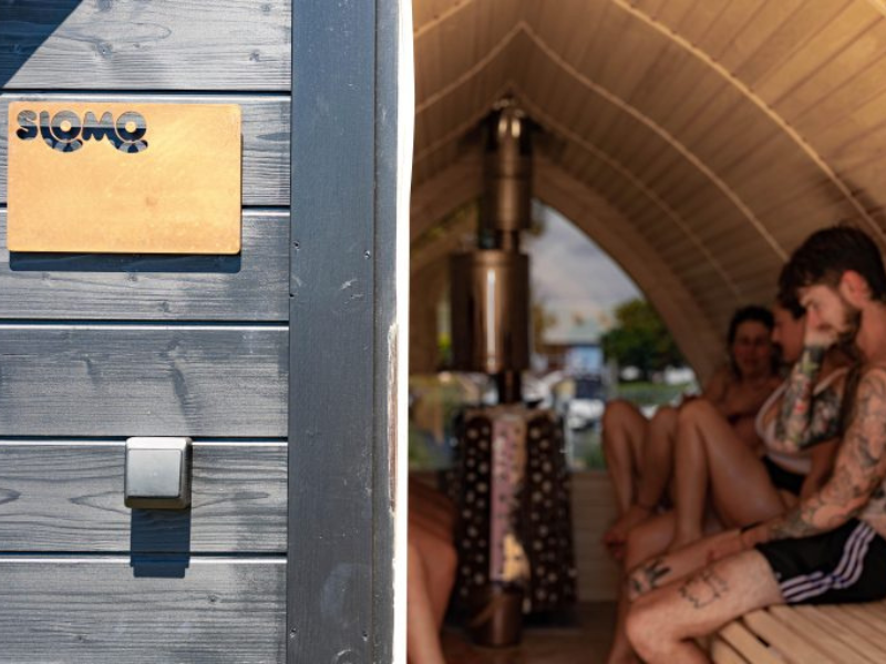 A shot of a mobile wooden sauna with people sitting inside