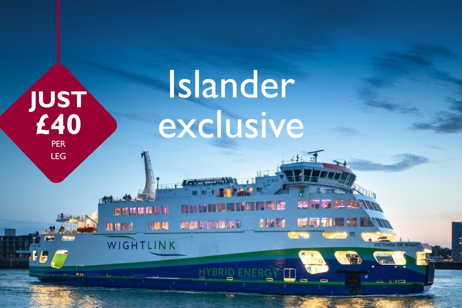 Wightlink’s Victoria of Wight hybrid ferry lit up at dusk, with text promoting an Islander exclusive offer of £40 per leg.
