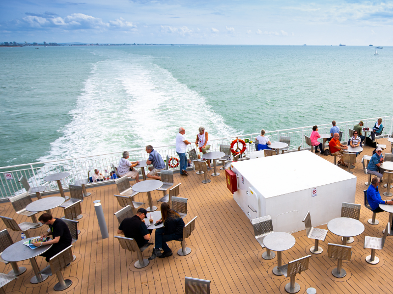 Passengers on the sundeck of a Wightlink ferry, sailing towards the Isle of Wight