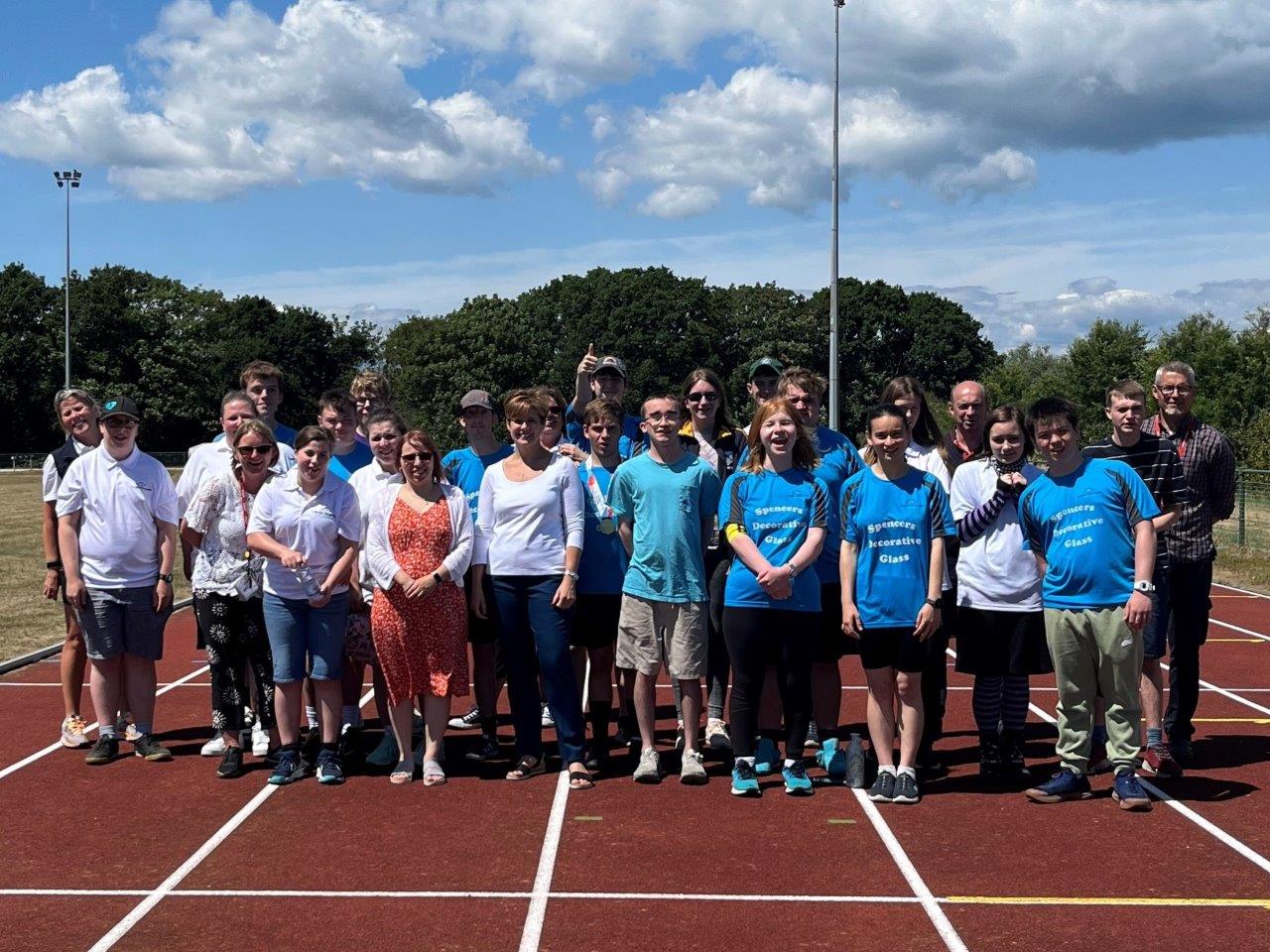 A large group of children from Sporting Opportunities Isle of Wight are standing together on a basketball pitch
