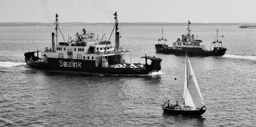 Black and white image of Sealink ferries including Caedmon sailing in the Solent, with a yacht in the foreground.