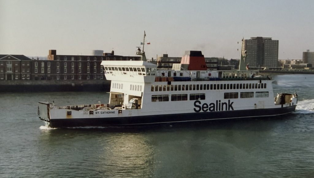 Sealink ferry St Catherine sailing in Portsmouth Harbour, showing white and blue livery with red funnel and city buildings in the background.