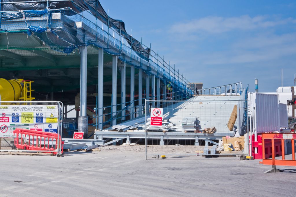 Construction work at Gunwharf showing the upper vehicle marshalling area under development, with scaffolding, safety barriers and signage in place.
