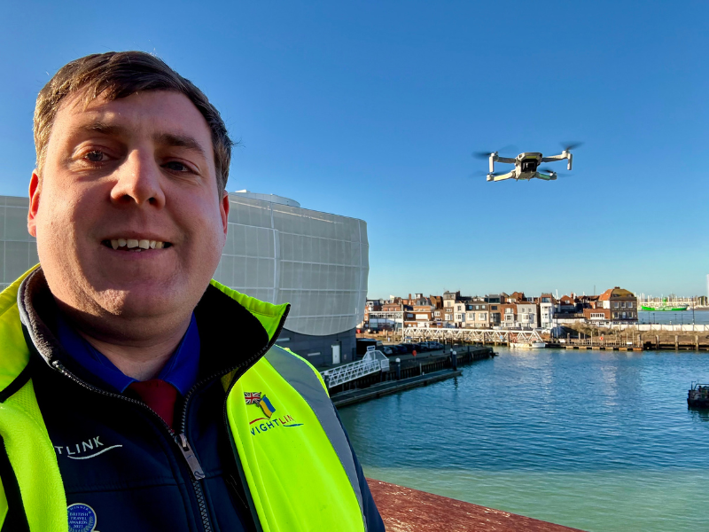A man in a high visibility jacket and Wightlink uniform flies a drome over The Camber Dock in Portsmouth Harbour