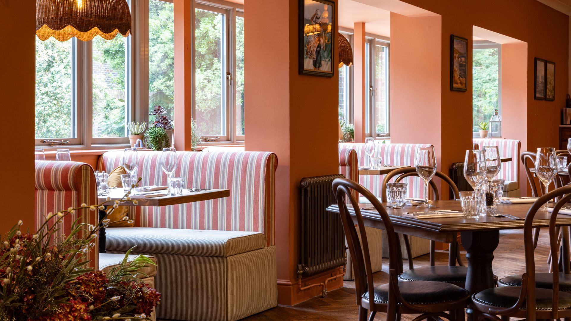 Bright and welcoming dining room at The Ropemaker with wooden tables, striped seating and large windows letting in natural light.