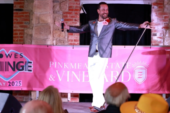 Performer singing on stage in an intimate Cowes Fringe venue with audience seated nearby
