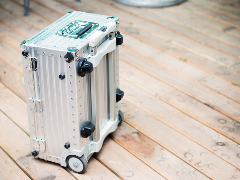 A silver metal suitcase or storage case with wheels and a handle
