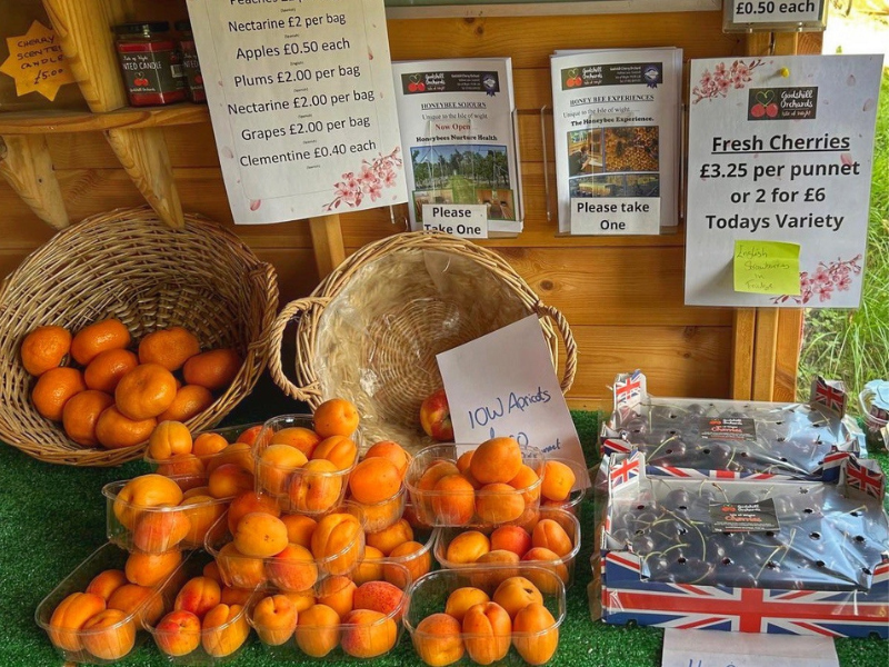A table of locally grown produce - cherries and apricots- at a farm shop