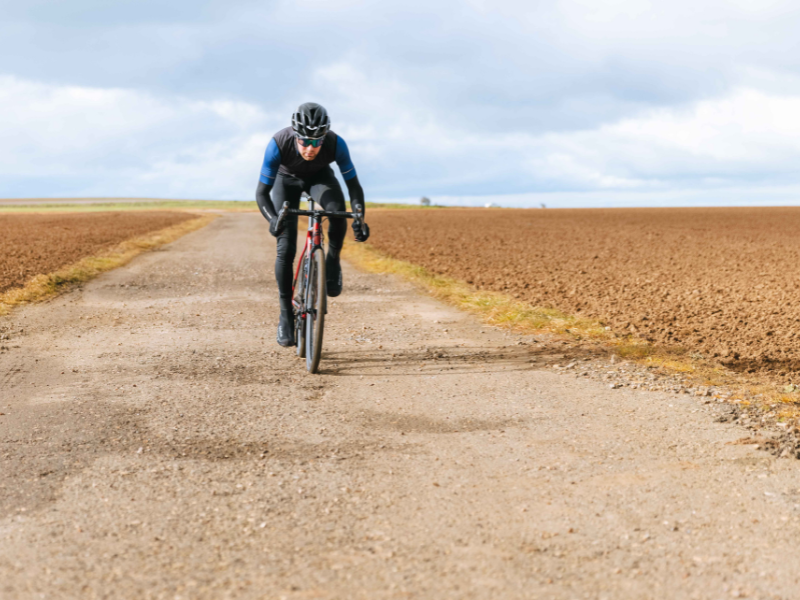 A man cycling along a gravel track