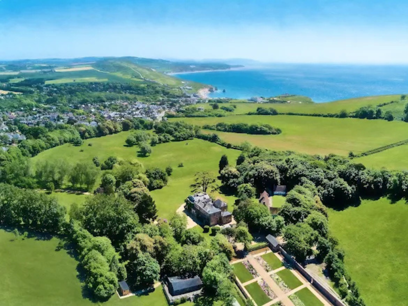 An aerial view of an estate on the Isle of Wight - the former home of Lord Tennyson - showing green rolling fields and coast, with the estate and house in the foreground
