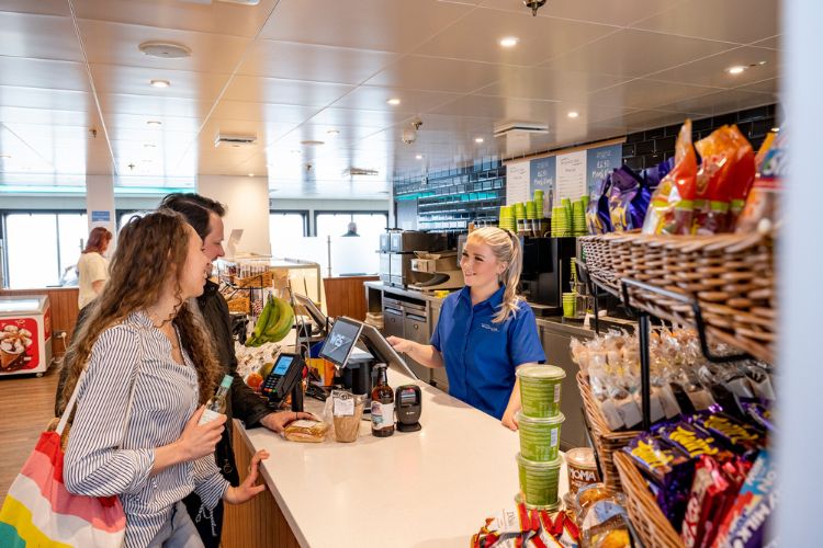 Passengers purchasing food and drinks at the Wight Taste onboard café.
