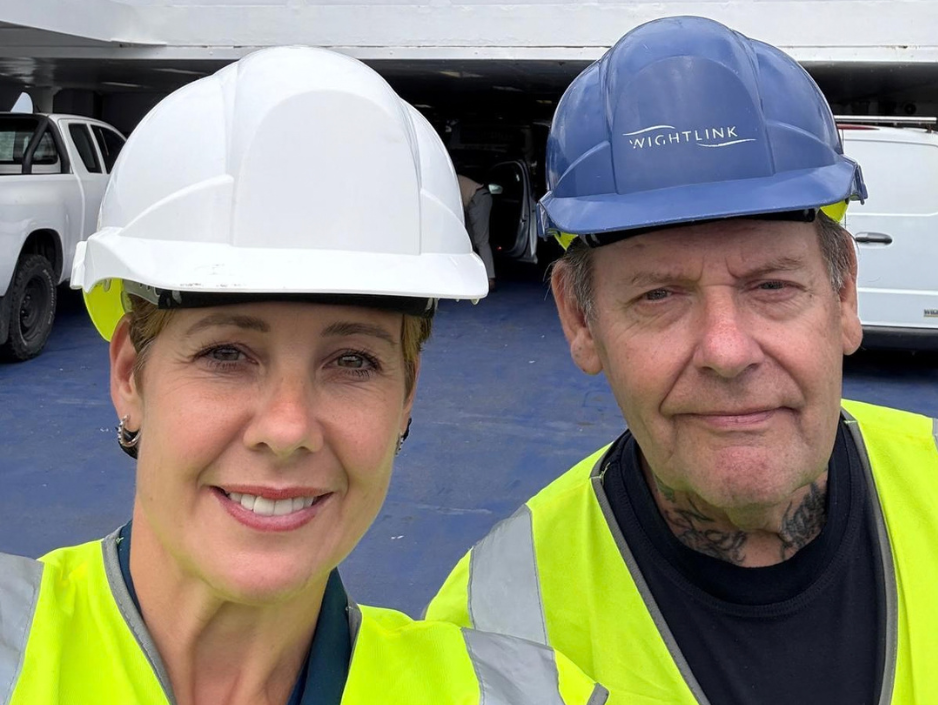 Wightlink Chief Executive Katy Taylor and a crew member wearing safety helmets and high-visibility clothing on the vehicle deck of a Wightlink ferry.