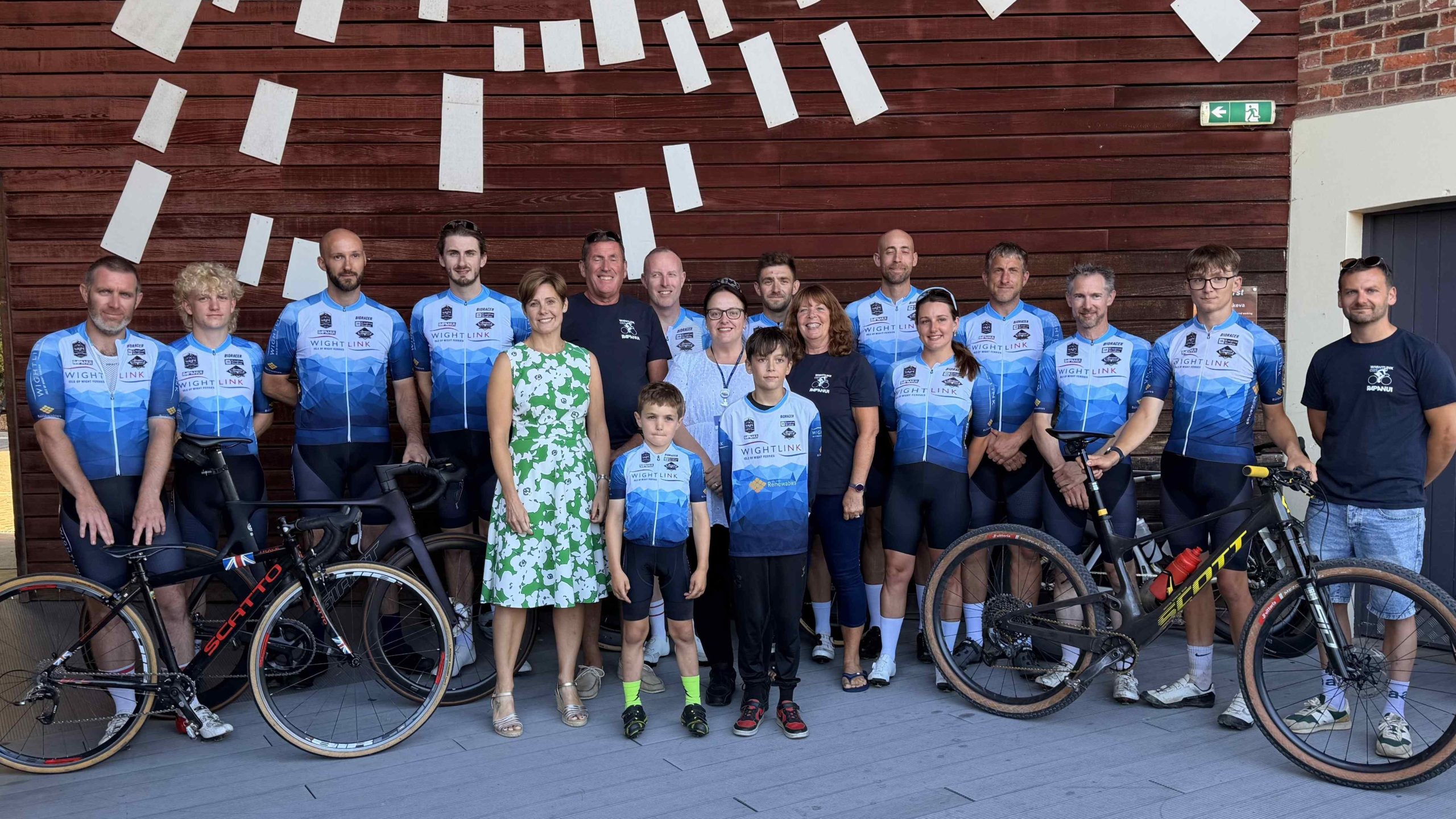 Cyclists from the Wightlink-supported CRT team gather with supporters and their bicycles at a community event on the Isle of Wight.